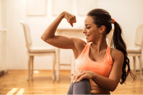 Woman Flexing Her Muscles After Body Sculpting Treatment